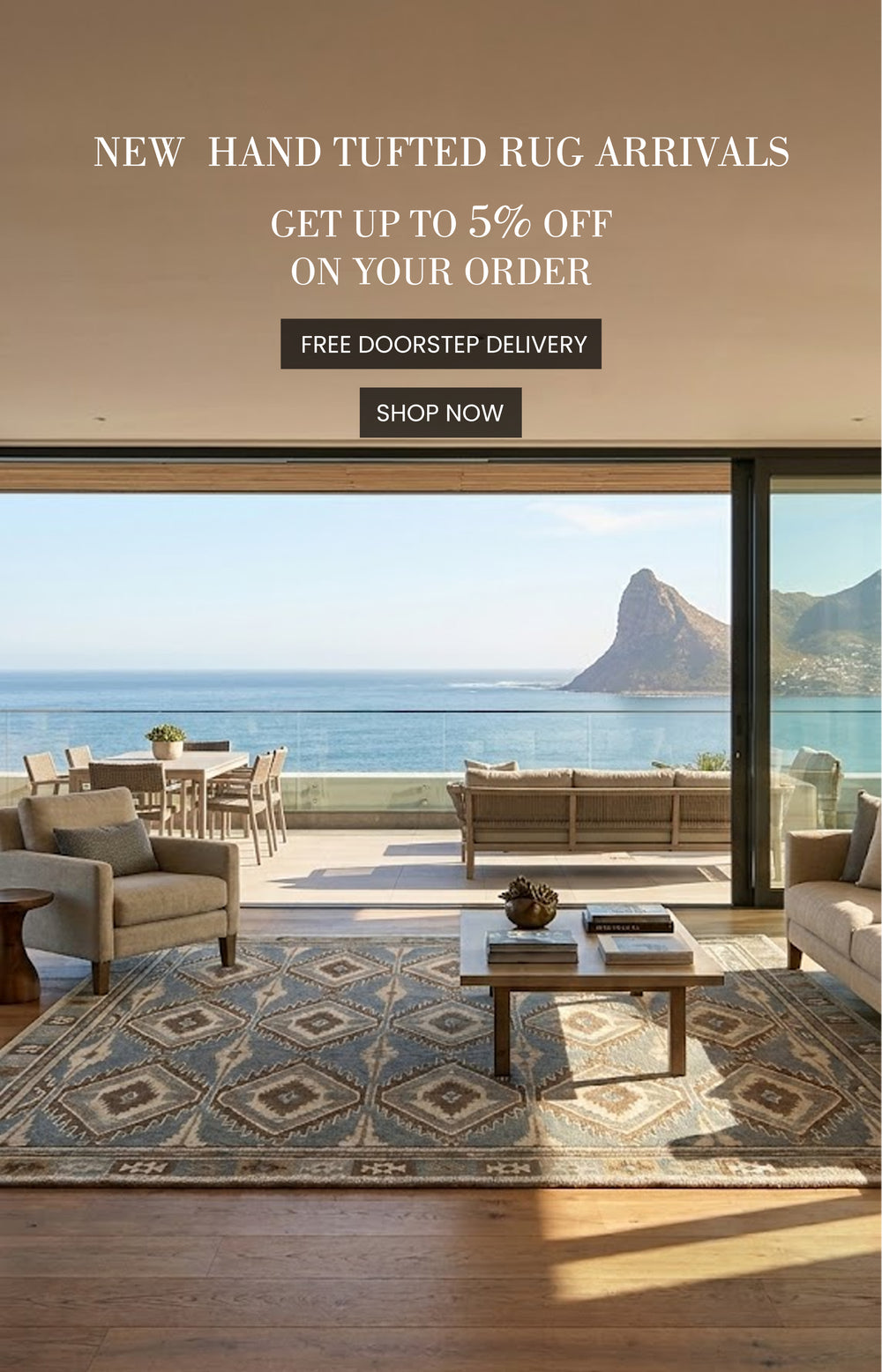 Living room with a large rug, chairs, and a view of the ocean and mountains.